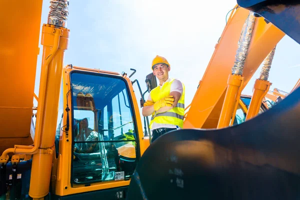 Asiatischer Bauarbeiter in Bagger auf Baustelle — Stockfoto