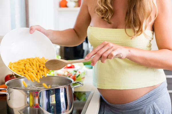 Femme enceinte cuisine des pâtes — Photo