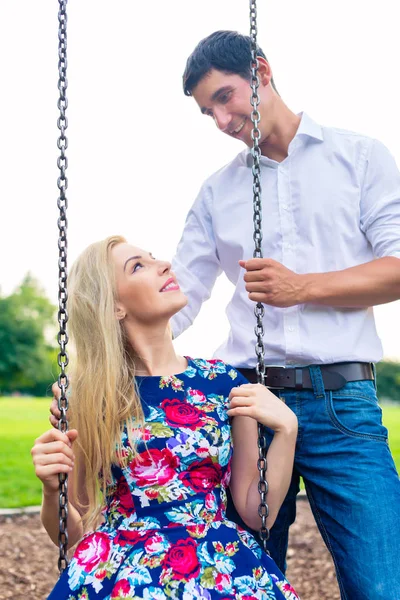 Man and woman on swing — Stock Photo, Image