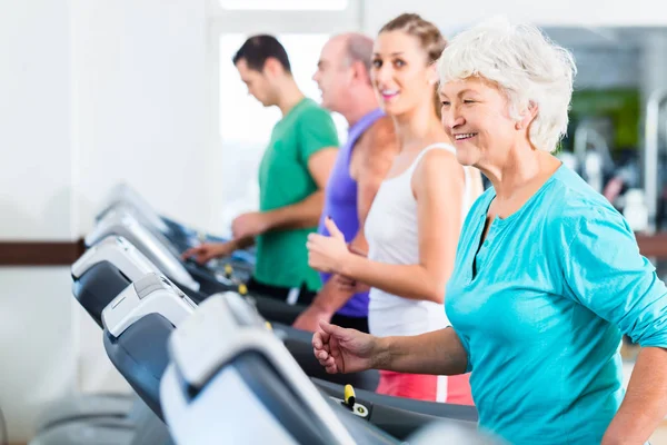 Grupp med ledande personer på löpband i gym — Stockfoto