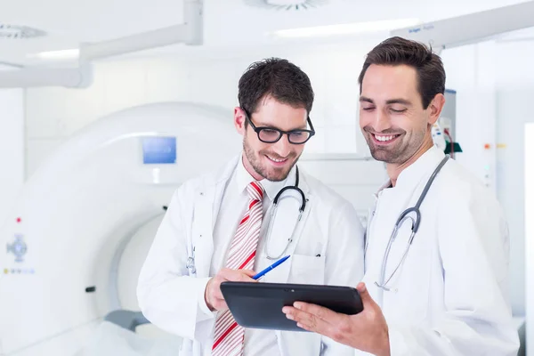 Médicos discutiendo imágenes de tomografía computarizada — Foto de Stock