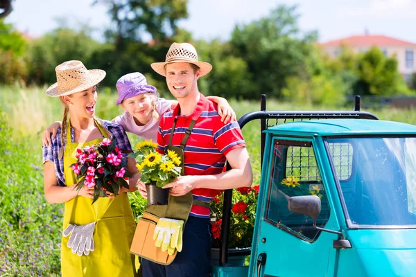 Famiglia in giardino con fiori — Foto Stock