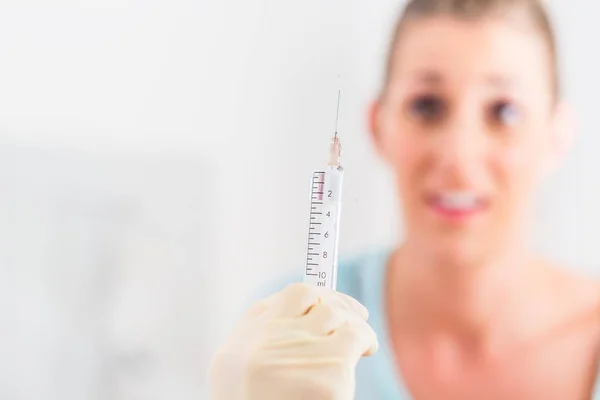 Woman at doctor fearing the syringe — Stock Photo, Image