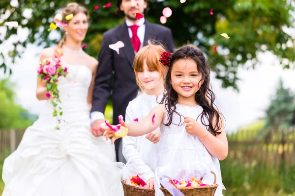 Bruidspaar en bruidsmeisje douchen bloemen — Stockfoto