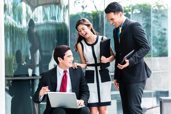 Asiatische Geschäftsleute arbeiten draußen am Laptop — Stockfoto