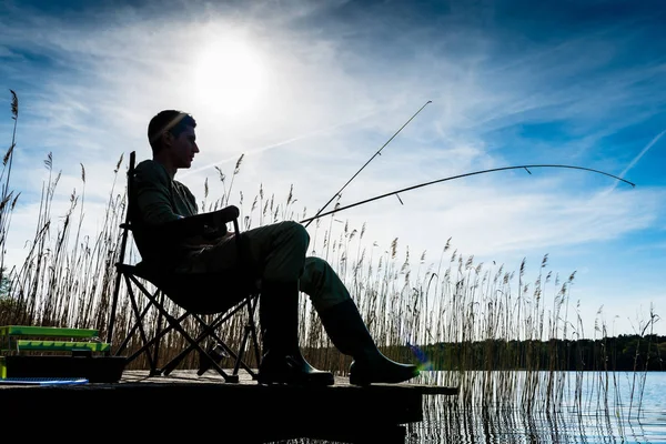 Fisherman or Angler at lake in Sunrise backlit — Stock Photo, Image
