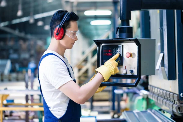 Trabalhador asiático operando CNC metal pular na fábrica — Fotografia de Stock