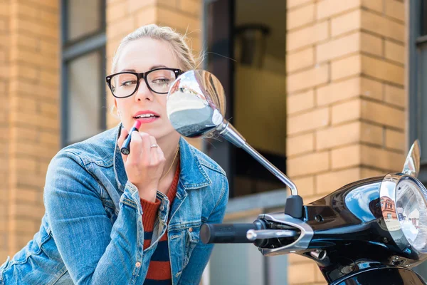 Kız makyaj yapmak için dikiz ayna scooter kullanır — Stok fotoğraf