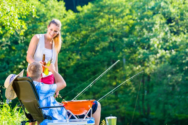 Pareja de mujer y hombre tomando cerveza mientras pesca deportiva —  Fotos de Stock