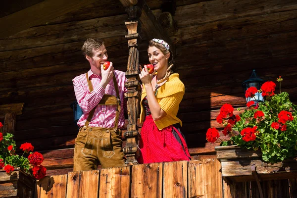 Couple dans les vêtements traditionnels devant la cabane de montagne — Photo