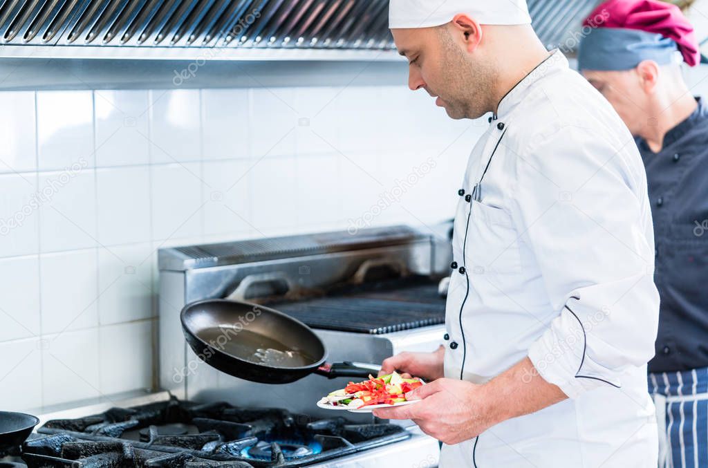 Chefs in restaurant kitchen cooking