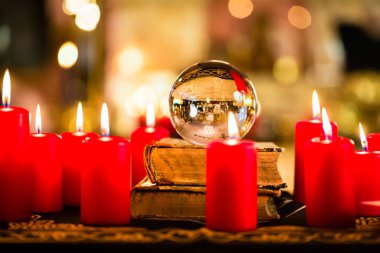 Crystal ball in the candle light to prophesy clipart
