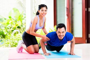 Asyalı kadın adam push-up ile yardım