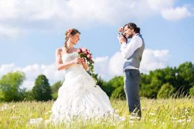 Evlilik çift çayır üzerinde fotoğraf çekmek
