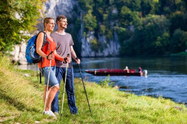 Man and woman hiking at Danube river in summer clipart