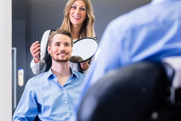 Peluquero mostrando al cliente el nuevo corte —  Fotos de Stock