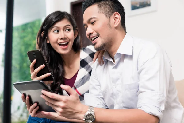 Indonéské pár doma pomocí tabletového počítače — Stock fotografie