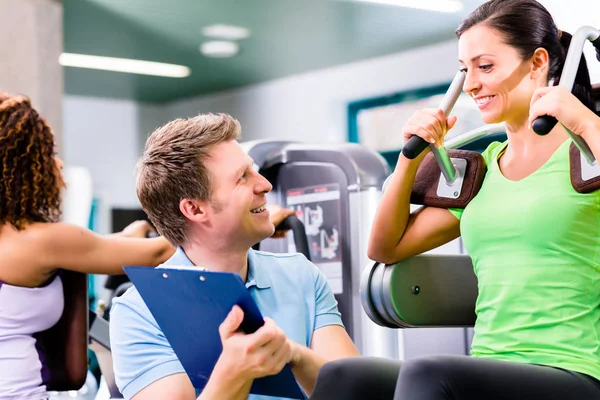 Vrouw met personal trainer doet sport und fitness — Stockfoto