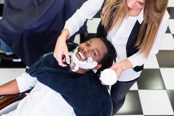 Cliente na barbearia com creme de barbear — Fotografia de Stock