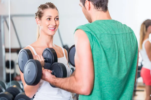 Junges Paar im Fitnessstudio hebt Hanteln — Stockfoto