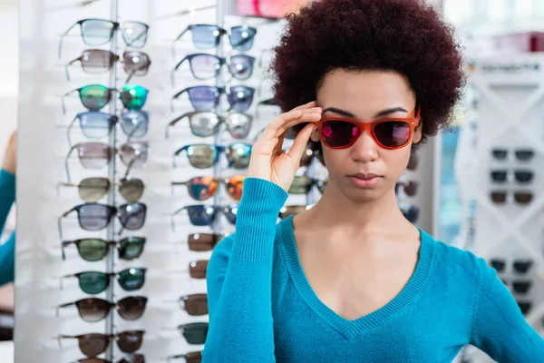 Zwarte vrouw dragen van een zonnebril in opticien shop — Stockfoto