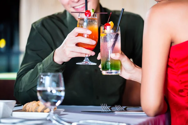 Asian couple drinking cocktails
