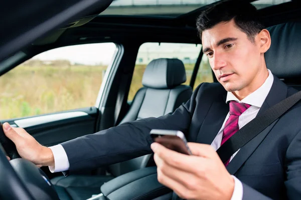 Homem mensagens de texto durante a condução de carro — Fotografia de Stock