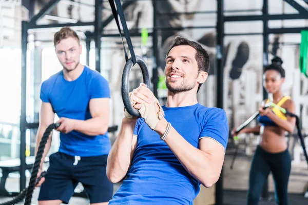 Man at rings doing fitness exercise — Stock Photo, Image
