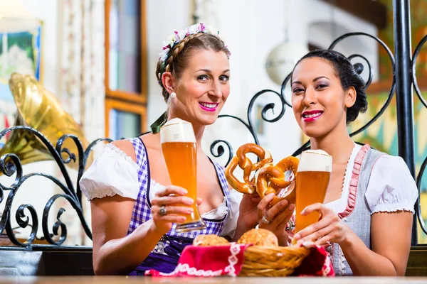 Přítelkyně se preclík a piva v bavorském hostinci — Stock fotografie