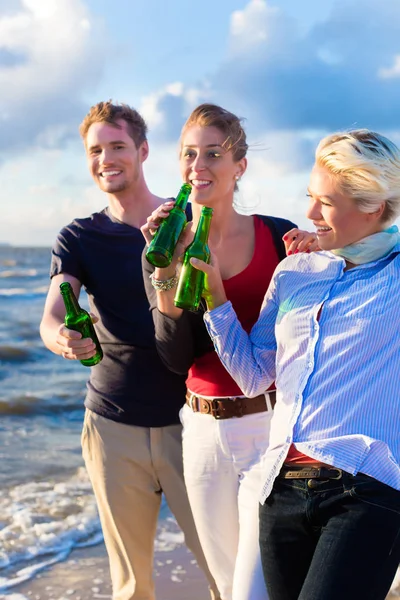 Amici che bevono birra in bottiglia in spiaggia — Foto Stock