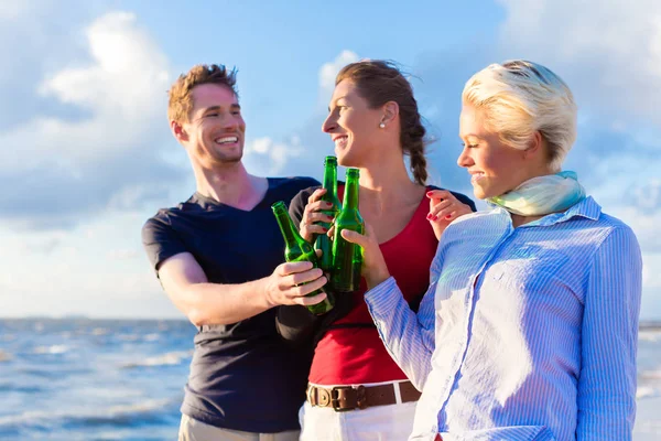 Amigos bebendo cerveja engarrafada na praia — Fotografia de Stock