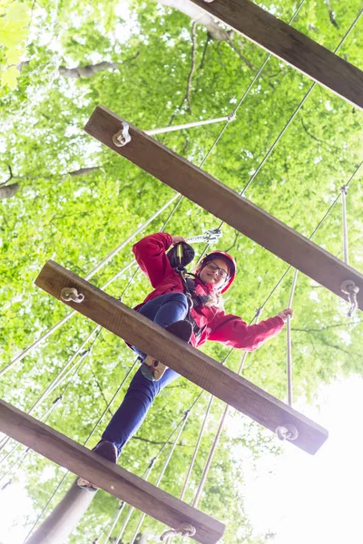 Niño caminando en puente de cuerda en curso de escalada —  Fotos de Stock