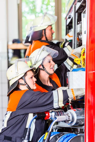 Bomberos que fijan la manguera — Foto de Stock