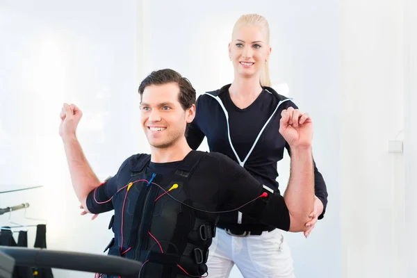 Man met ems opleiding met personal trainer — Stockfoto