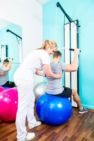 Fysiotherapeut doen sport revalidatie met patiënt — Stockfoto