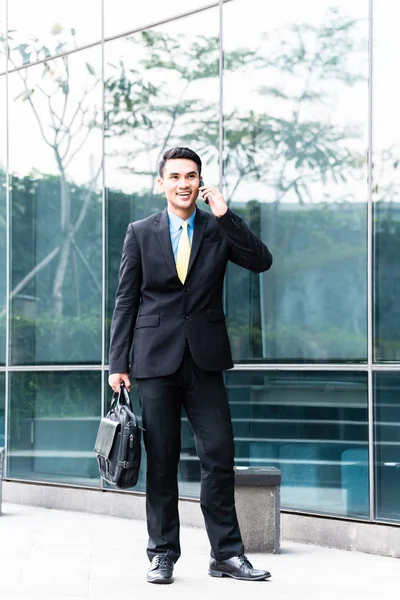 Asiático hombre de negocios hablando con teléfono celular fuera —  Fotos de Stock