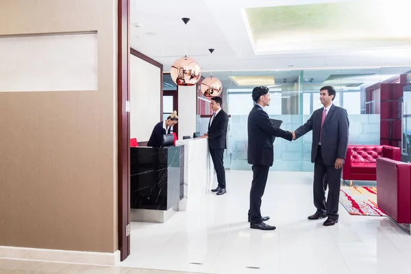 stock image Manager welcoming business associate in office lounge