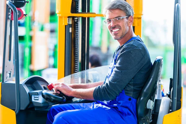 Baumarkt-Verkäuferin fährt Gabelstapler — Stockfoto