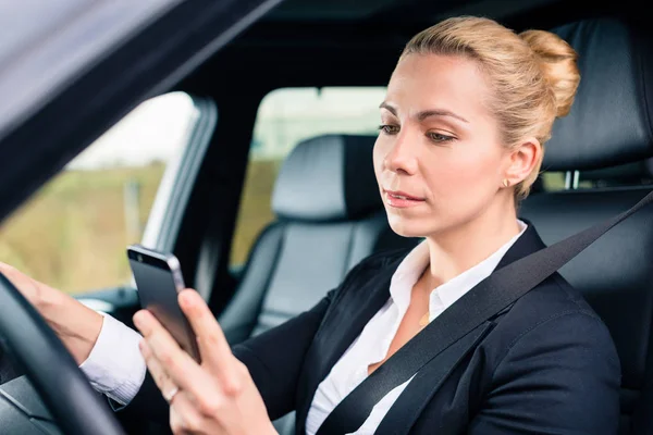 Woman texting while driving by car — Stock Photo, Image