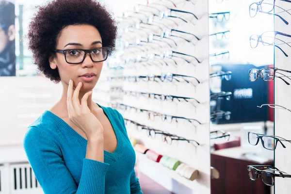 Černá žena se snaží na brýle v optik úložišti — Stock fotografie