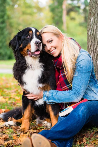 Frau kuschelt mit Hund im Park — Stockfoto