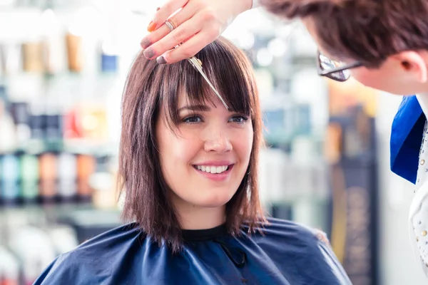 Hairdresser cutting woman hair — Stock Photo, Image