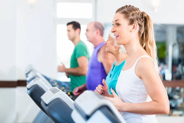 Grupp med ledande personer på löpband i gym — Stockfoto