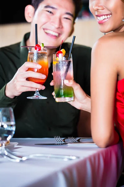 Asiatisches Paar trinkt Cocktails in schicker Bar — Stockfoto