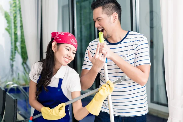 Indonesian couple having fun cleaning the home — Stock Photo, Image