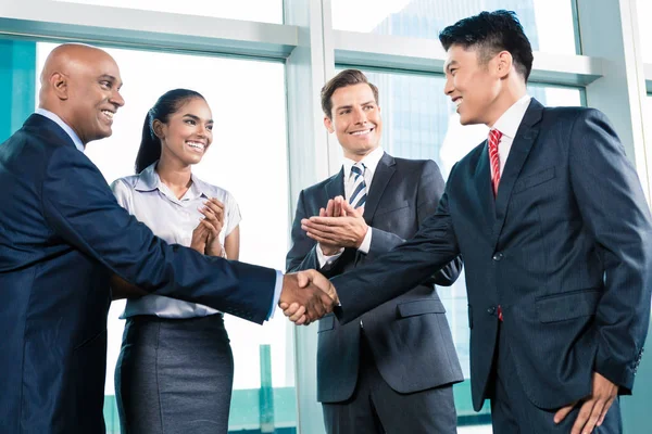 Business handshake in lofty office with city view — Stock Photo, Image