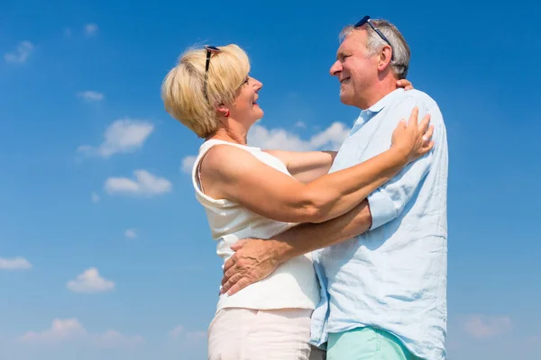 Starší muž a žena vzájemně objímat — Stock fotografie