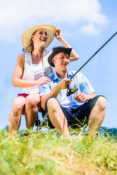 抱っこを楽しむ湖で釣り竿を持つ男 — ストック写真