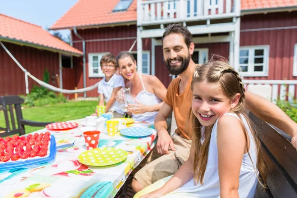 Familie koffie drinken en eten taart voorkant van huis — Stockfoto