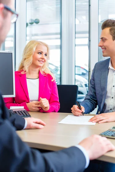 Homme signant contrat de vente pour l'automobile chez le concessionnaire automobile — Photo